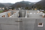 A last section of concrete wall is lowered into place in the cellar - all other walls are in place.